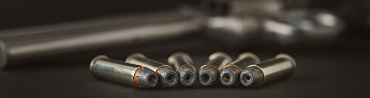 357 Caliber hollow point bullets near revolver pistol gun on black background